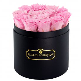 Světle růžové věčné růže v černém kulatém flowerboxu