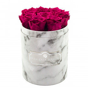Růžové věčné růže v malém bílém mramorovém flowerboxu